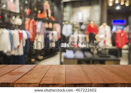 Empty brown wooden table and De focused/blurry background of Sports clothing store in Inter Sport store,with bokeh image, for product display montage,can be used for montage or display your products
