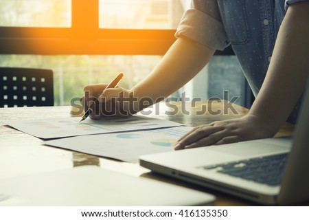 Male manager putting his ideas and writing business plan at workplace,man holding pens and papers, making notes in documents, on the table in office,vintage color,morning light ,selective focus.