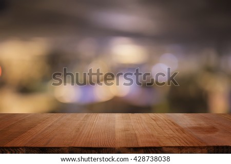 Empty brown wooden table and blur background of abstract blurred background of resturant lights ,for product display montage,can be used for montage or display your products