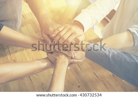 Teamwork concept,Business team standing hands together in the loft office.people joining hands for cooperation success business,win in every thing,vintage color