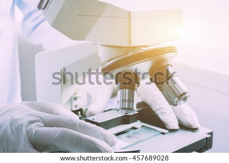 medical laboratory, scientist hands using microscope for chemistry test samples,examining samples and liquid,Medical equipment. microscope,Scientific and healthcare research background.vintage color