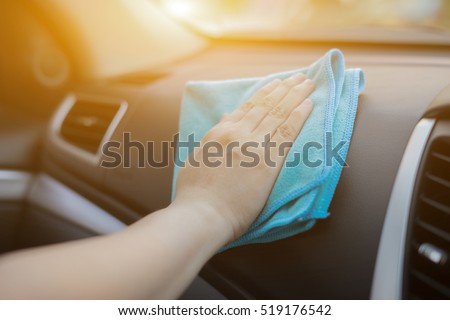 Hand with microfiber cloth cleaning car.woman cleaning car interior - car detailing and valeting concept in car wash car care station ,selective focus