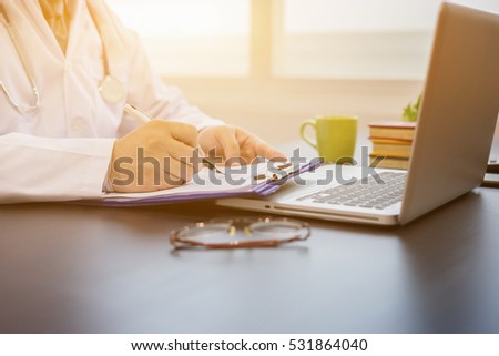 Male Doctor with files and stethoscope on hospital corridor holding clipboard and writing prescription with pen,Nurse use exam Health care and medical concept,test results, registration patient data