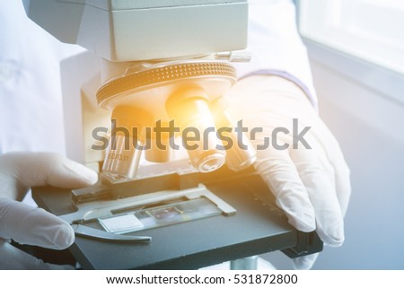 medical laboratory, Doctor or scientist hands using microscope for chemistry test samples,examining ,Scientific and health care research background.vintage color