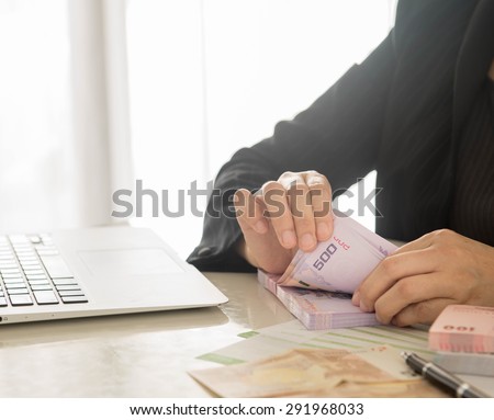 Bank employees are counting banknotes received or paid to customers.