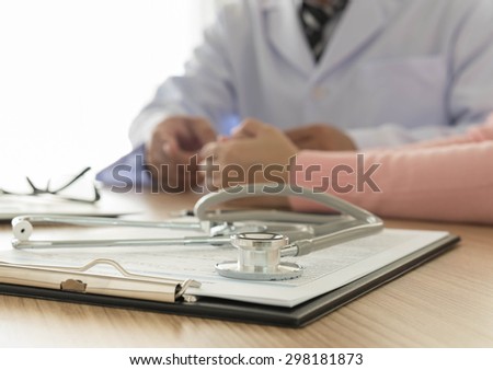 stethoscope and medical documentation  with doctor and patient background