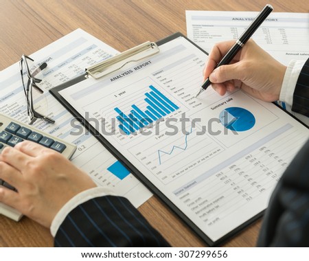 accountant are analyzing the data from the report. working at office