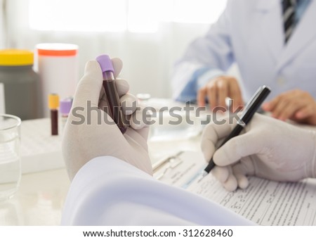 Doctor holding a bottle of blood sample in lab. science and medical concept