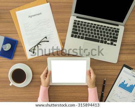 woman working at office desk with documents and using tablet computer.  top view . accounts concept.