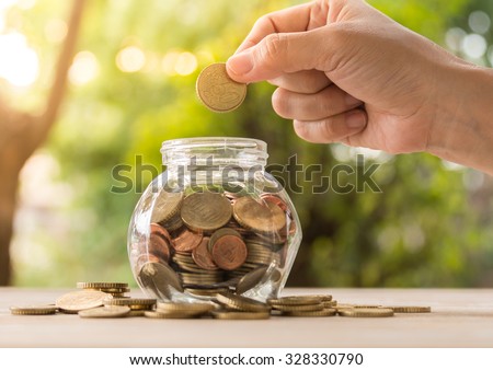 hand\'s women putting golden coins in money jar. account concept,business concept,finance concept, savings concept.