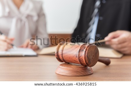 Judge gavel with lawyers having team meeting in law firm background. Concepts of legal services.