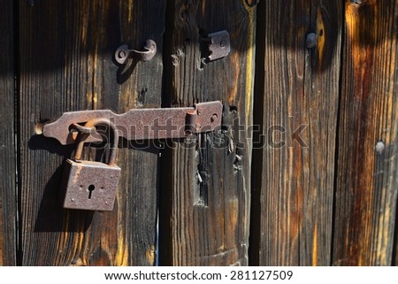 Old, rusty padlock on the wooden hangar doors at the National Museum of Culture and Life Pirogovo, Kiev, Ukraine, Europe