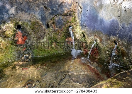 Water Falling Out Of Multiple Holes In a Rock Of a Natural Water Source In Catalonia Spain