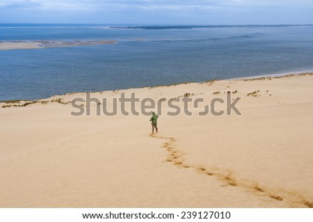 Woman goes down the Great Dune of Pyla, Arcachon (France)