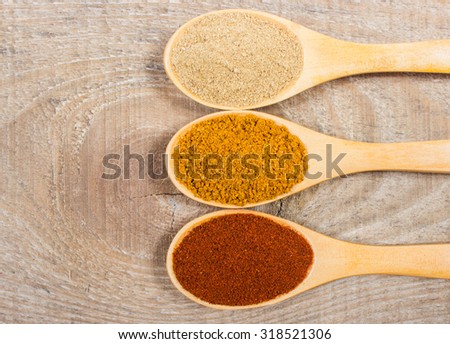 Spice powder on a wooden background. Paprika, curry and ginger on a wooden spoon.