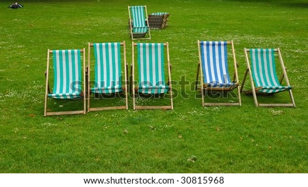 Lawn chairs in St James\'s Park with person lying next to them