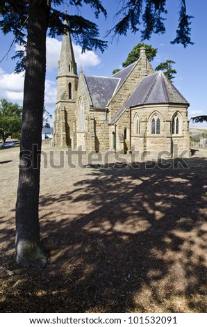 Sandstone church framed by tree.  Wesley Church, (now the Uniting Church) Ross, Tasmania, Australia. The church was built in 1885.