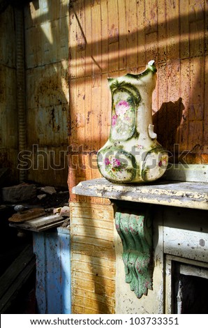 Broken vase on mantle shelf in dilapidated house