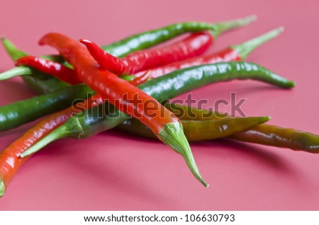 Pile of chilli peppers on hot pink background