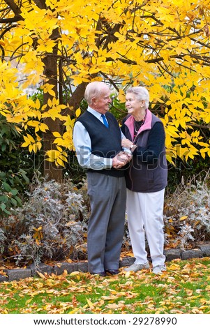 Golden Years Senior couple sharing an affectionate moment near tree with golden leaves