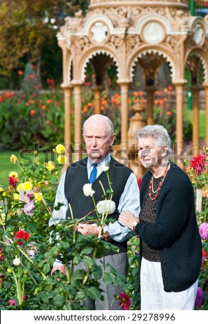 Senior Couple admiring dahlias near ornate Victorian drinking fountain