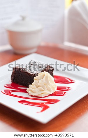 Chocolate brownie with whipped cream and raspberry coulis