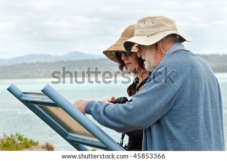Fifty year old woman and eighty year old man reading sign at Nature Reserve