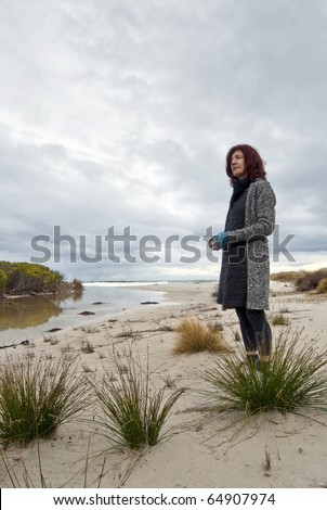 Contemplative woman at remote beach setting, White Sands, Tasmania, Australia