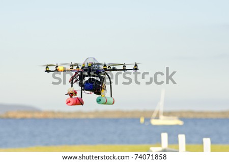 Remote-controlled surveillance helicopter  flying towards yacht carrying camera
