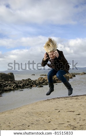 Attractive woman at Tasmanian beach in long Winter coat