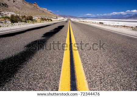 Open road in the desert with blue sky near Death Valley National Park, California. United States.