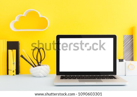 Laptop mockup on creative yellow desk.