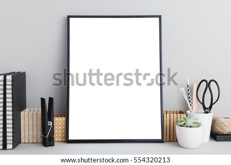 Black frame mock up on gray background, office supplies, stylish scissors, small plant. Arranagement inspiration.