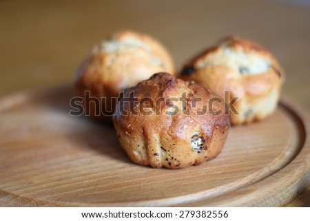 three yellow muffin with raisins, on a wooden Board, handmade on a wooden table for Breakfast - lunch-dinner,small