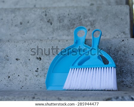 Broom and dustpan on a concrete staircase