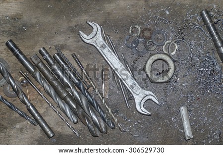 universal key , nut, metal shavings , drill on the workplace in the garage