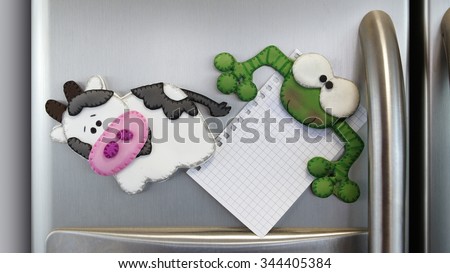 little cow magnet pin and funny frog magnet pin with blank note stuck in an aluminum double door refrigerator