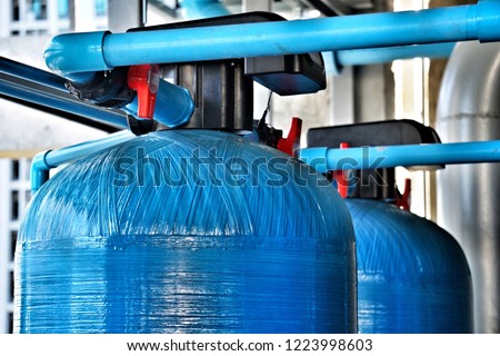 The upper tank of the water softener system.
