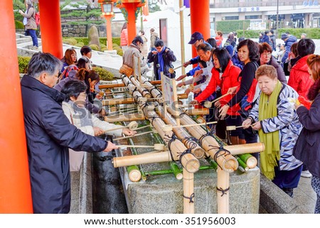 Kyoto, Japan - December 29, 2014 : Tourists washing hands and mouths before enter Fushimi Inari shrine
