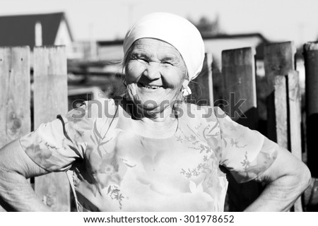 Black and white Grandma smiles near a fence Summer