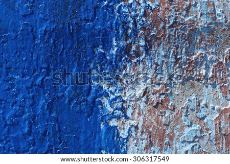 Flaked paint metal painted with fresh layer of blue paint with brush