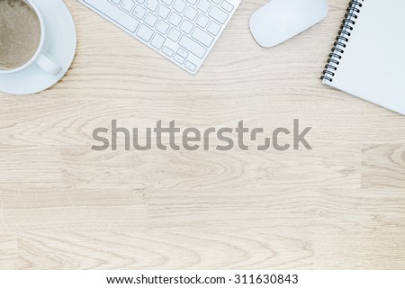 Office table with notepad, mouse,keyboard , coffee cup. View from above with bottom copy space / clean desk from top view