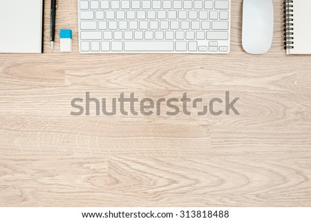 Office table with notepad, mouse,keyboard,rubber,book with wood desk texture background. View from above with bottom copy space / clean desk from top view
