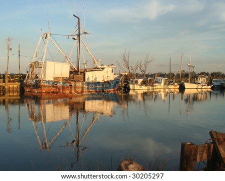 Rusty Gulf Shrimp Boat Past it\'s Prime with Reflections on Calm Ocean Waters