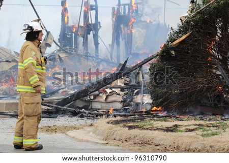 TONTITOWN, AR - FEBRUARY 4: A fireman watches as a fire completes it's awful destruction after a control burn exercise on February 4, 2012 in Tontitown, AR.  The exercise was open to the public.