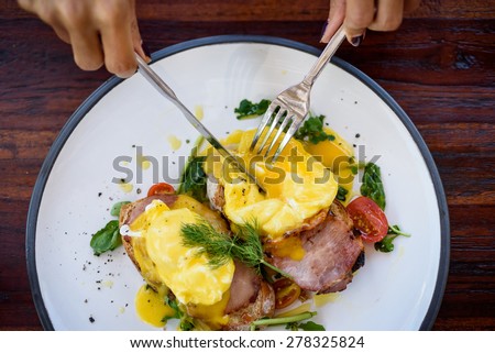 Eggs Benedict with bacon, toast and watercress salad.