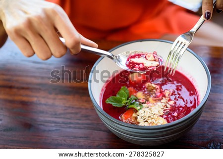 Frozen mango and dragon fruit smoothie bowl, with muesli and strawberries.