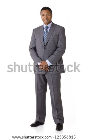 Full length portrait of an African American businessman smiling wearing a suit and tie isolated on a white background
