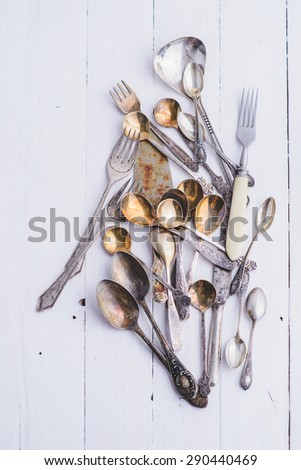 Cutlery in vintage style on the wooden background - forks, spoons, knives/Old cutlery from different  vintage  spoons, forks and knives