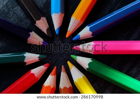 Colorful pencils arranged in circular pattern